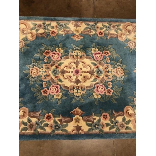 359 - Chinese wool rug of sculpted style with typical designs of flowers and  against a blue grey  back gr... 