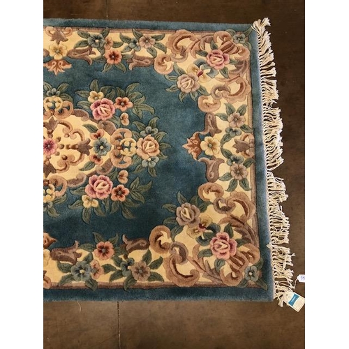 359 - Chinese wool rug of sculpted style with typical designs of flowers and  against a blue grey  back gr... 