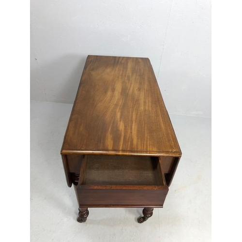 371 - Pembroke table in flame mahogany on turned legs on casters, drawers to either end