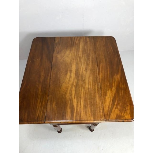 371 - Pembroke table in flame mahogany on turned legs on casters, drawers to either end