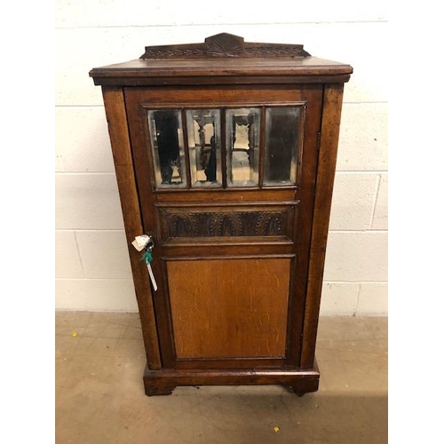 414 - Oak cupboard with bevelled glass inserts and carved panel, opening to three shelves, with original k... 