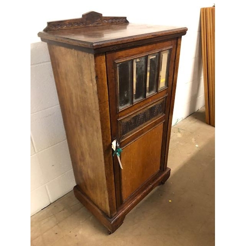 414 - Oak cupboard with bevelled glass inserts and carved panel, opening to three shelves, with original k... 