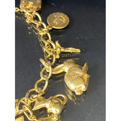 42 - 9Ct Gold charm bracelet with a collection of 9ct gold charms, to include, rabbit, Dolphins, Boot, Mo... 