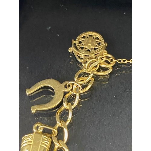 42 - 9Ct Gold charm bracelet with a collection of 9ct gold charms, to include, rabbit, Dolphins, Boot, Mo... 