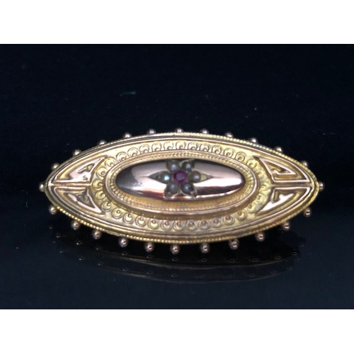 30a - 9ct Gold mourning brooch set with seed pearls and a central Garnet approx 44mm wide & 3.5g