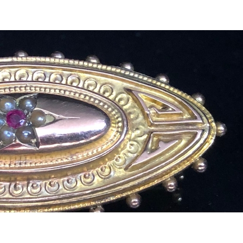 30a - 9ct Gold mourning brooch set with seed pearls and a central Garnet approx 44mm wide & 3.5g