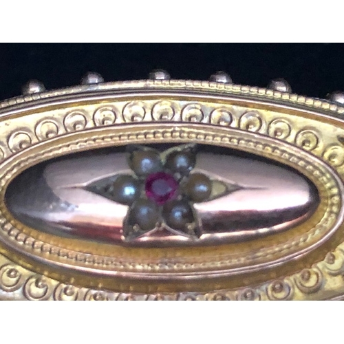 30a - 9ct Gold mourning brooch set with seed pearls and a central Garnet approx 44mm wide & 3.5g