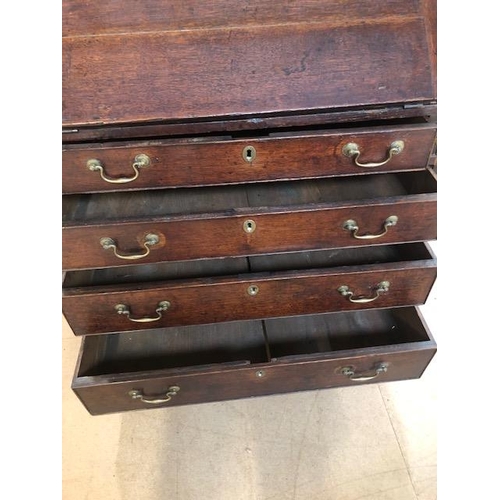 100 - Antique Georgian Oak Bureau with four drawers and fall front opening to pigeon holes and small drawe... 