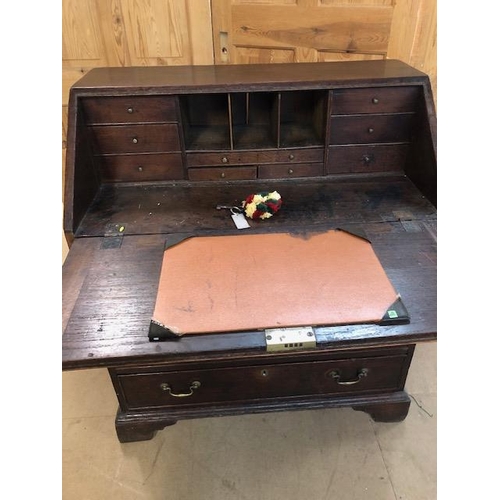 100 - Antique Georgian Oak Bureau with four drawers and fall front opening to pigeon holes and small drawe... 