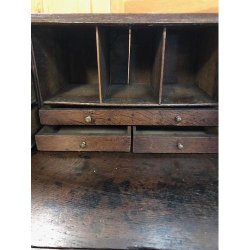 100 - Antique Georgian Oak Bureau with four drawers and fall front opening to pigeon holes and small drawe... 