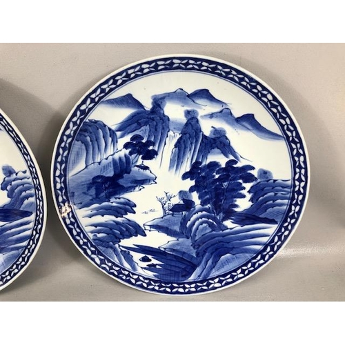 166 - Chinese blue and white ceramic charger plates, both decorated with a  landscape, impressed marks to ... 