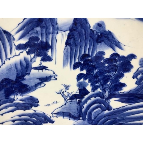 166 - Chinese blue and white ceramic charger plates, both decorated with a  landscape, impressed marks to ... 