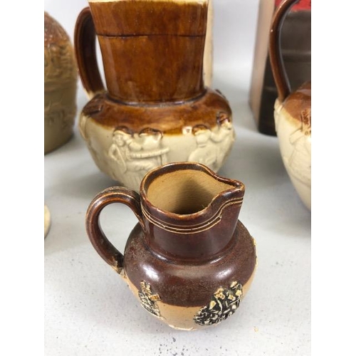 265 - Collection of salt glaze jugs and cider mugs along with a book shape bottle