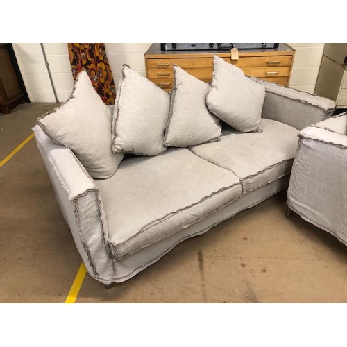 291 - Modern two seater sofa and matching arm chair by Designers Guild, with reverse  seam covers on metal... 