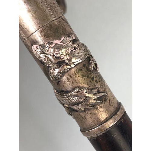 33 - Chinese silver and Coromandel walking stick, the silver coloured handle depicting a Dragon and with ... 