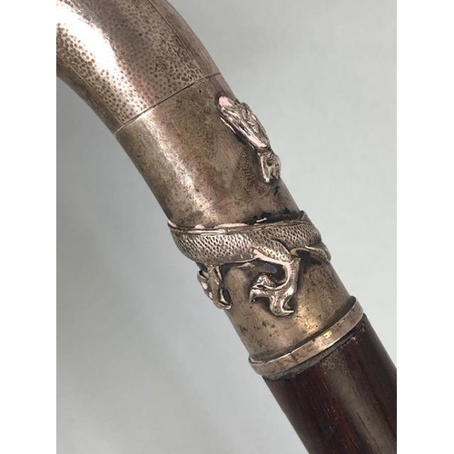 33 - Chinese silver and Coromandel walking stick, the silver coloured handle depicting a Dragon and with ... 