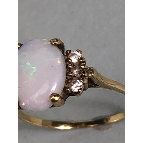 40 - Oval cut opal set in an unmarked yellow metal setting with 6 diamonds approximate size J 1.3g