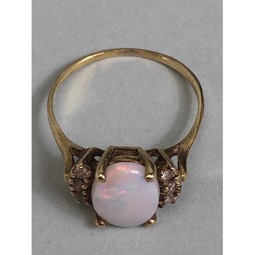 40 - Oval cut opal set in an unmarked yellow metal setting with 6 diamonds approximate size J 1.3g