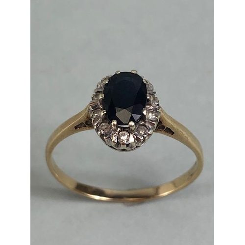 76 - 9ct gold ring set with an oval sapphire surrounded with diamonds approximately size R  and 2.1g