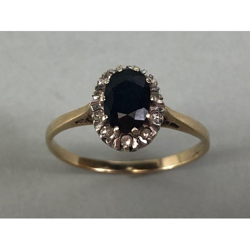 76 - 9ct gold ring set with an oval sapphire surrounded with diamonds approximately size R  and 2.1g