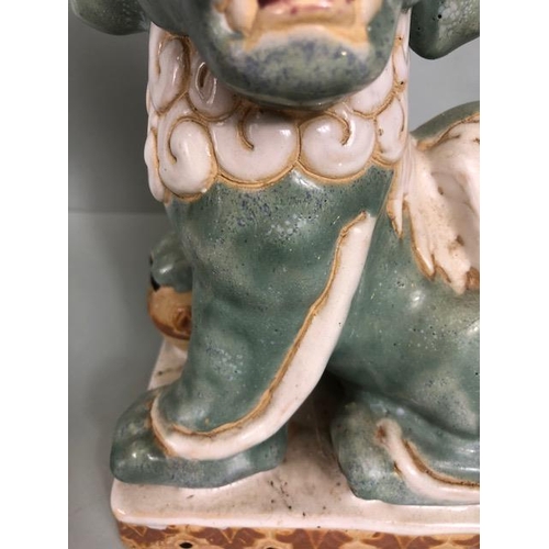 138 - Oriental Ceramics, Two Chinese pottery Foo or Shi Shi dogs glazed in celadon and cream each  approxi... 