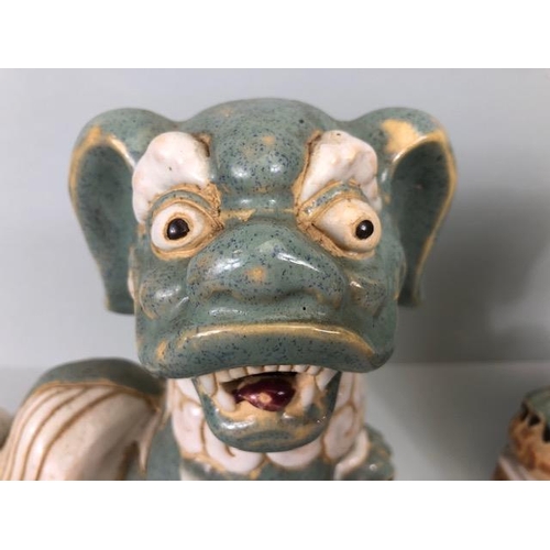 138 - Oriental Ceramics, Two Chinese pottery Foo or Shi Shi dogs glazed in celadon and cream each  approxi... 