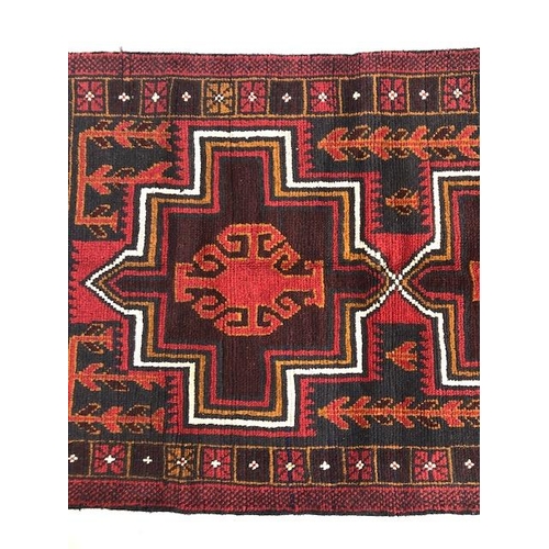 273 - Oriental hand knotted wool carpet Baluchi geometric patterns on a dark burgundy background approxima... 