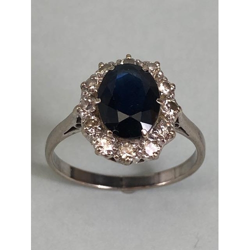 43 - 18ct white gold cluster ring of an oval cut sapphire surrounded with 12 diamonds, approximately 3.6g... 