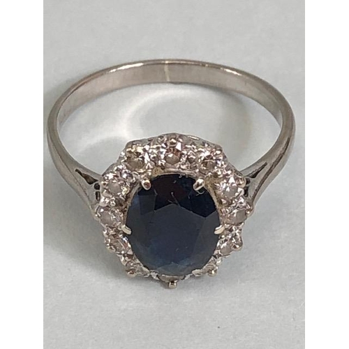 43 - 18ct white gold cluster ring of an oval cut sapphire surrounded with 12 diamonds, approximately 3.6g... 