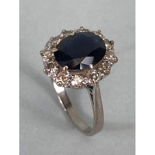 43 - 18ct white gold cluster ring of an oval cut sapphire surrounded with 12 diamonds, approximately 3.6g... 