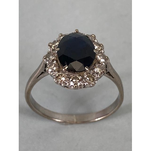 43 - 18ct white gold cluster ring of an oval cut sapphire surrounded with 12 diamonds, approximately 3.6g... 