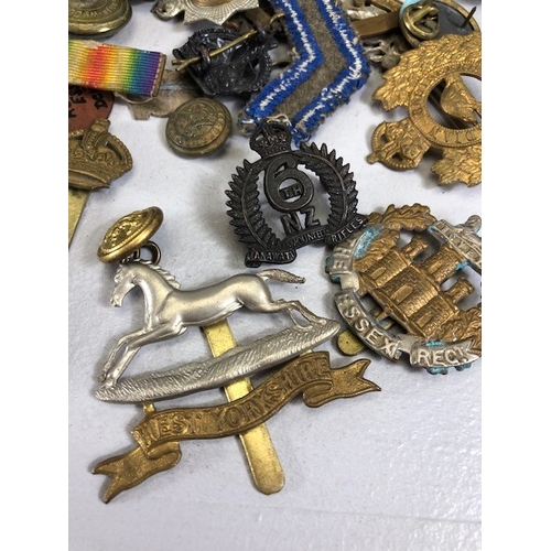 145 - Military interest collection of WW1 and WW2 items to include British and commonwealth cap badges col... 