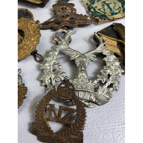 145 - Military interest collection of WW1 and WW2 items to include British and commonwealth cap badges col... 