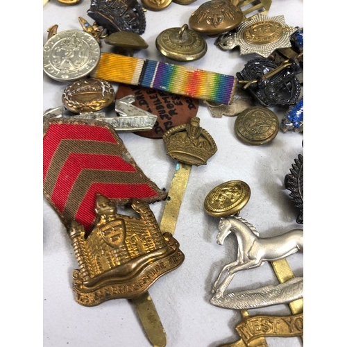 145 - Military interest collection of WW1 and WW2 items to include British and commonwealth cap badges col... 