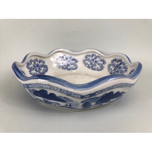 185 - Oriental ceramics, blue and white dish with fluted rim depicting a village landscape, unglazed base ... 