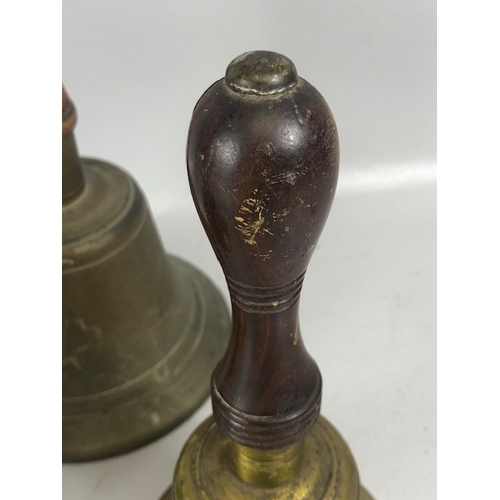 192 - Antique bells, three large hand bells of school type, with turned wooden handles, one marked 