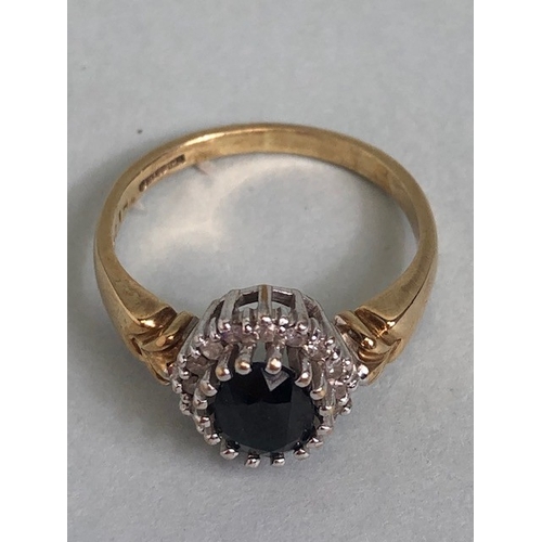 22 - 9ct Gold ring set with large dark faceted Sapphire and surrounded by Diamonds approx size 'L'