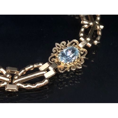 36A - 9ct Gold bracelet with four pale blue gemstones set in pierced panels approx 7cm in length and 5.7g