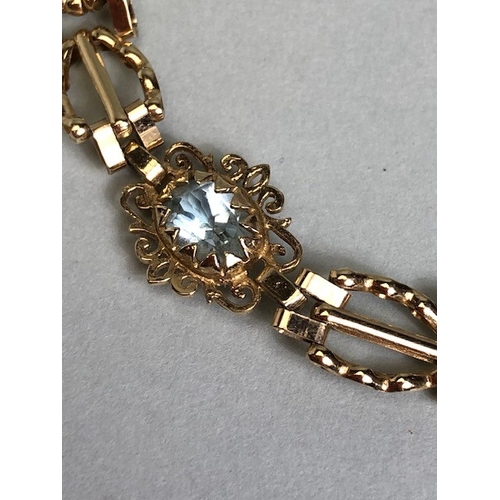 36A - 9ct Gold bracelet with four pale blue gemstones set in pierced panels approx 7cm in length and 5.7g