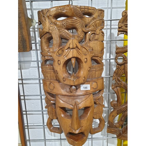 145 - Two wooden carved Aztec style wall masks, length 20.25