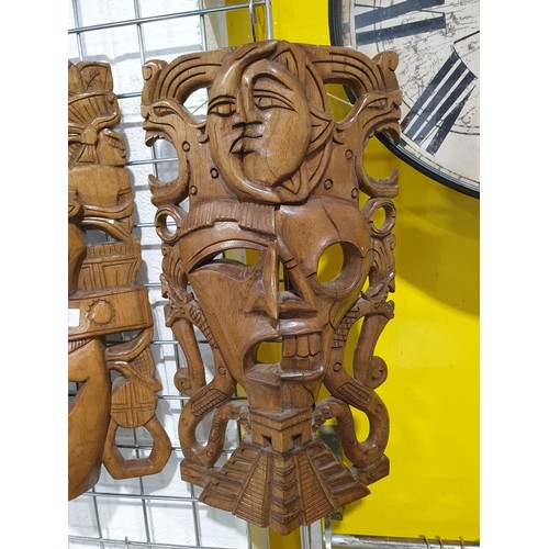 145 - Two wooden carved Aztec style wall masks, length 20.25