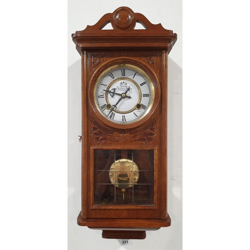 223 - An oak cased wall clock, the dial signed P. Watts & Son, length 21