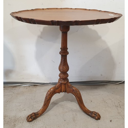 240 - An antique mahogany tip-up tripod table with carved legs on a baluster support with an oval pie crus... 