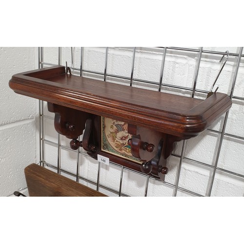 148 - An antique mahogany wall bracket with inset ceramic tile, width 18