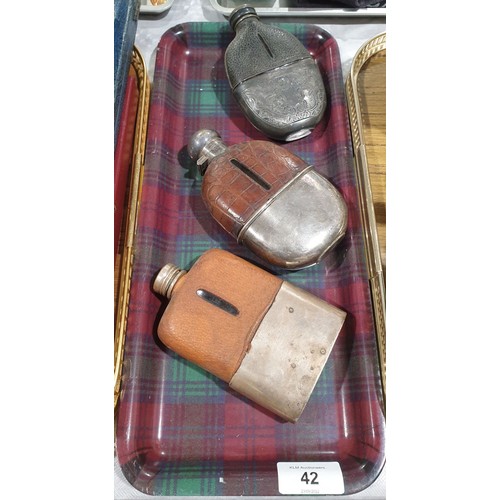 42 - An antique crocodile skin covered hip flask together with two other hip flasks. UK shipping £14.