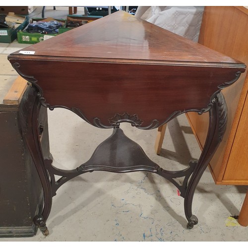 131 - An unusual early 20th century triangular drop leaf table with carved edges, diameter extended 31