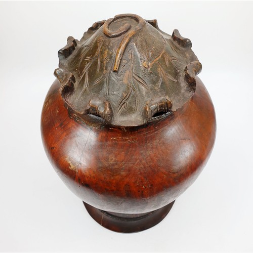 241 - An antique Chinese wooden baluster shaped vase, the lid carved as a water lily, height 12.5