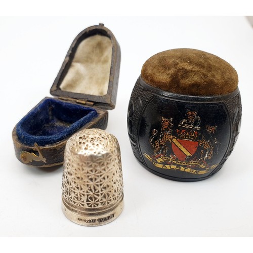 300 - An antique ebony pin cushion carved with clover leaves and the crest of Alston, height 1.5