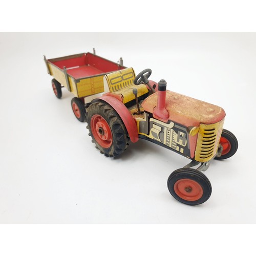 453 - A vintage Zetor tin plate model clockwork tractor and trailer. UK shipping £14.