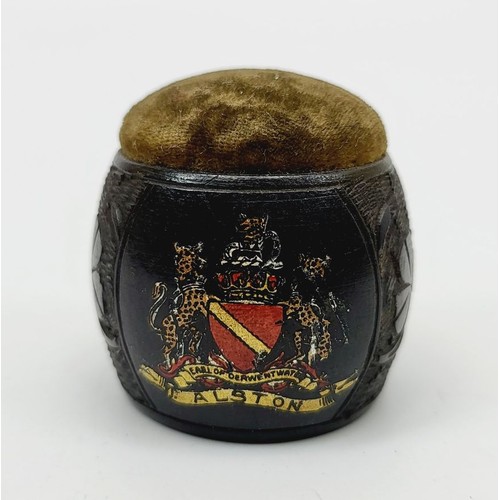 300 - An antique ebony pin cushion carved with clover leaves and the crest of Alston, height 1.5